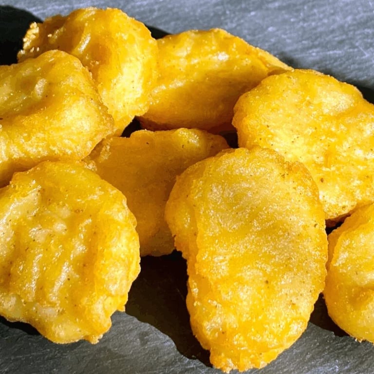Golden fried puffs or bhatura on gray surface, showing crispy texture and appetizing appearance